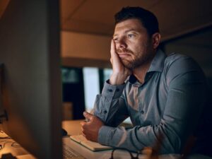 Man waiting on computer to display a website because his internet connection is slow due to the net neutrality repeal.